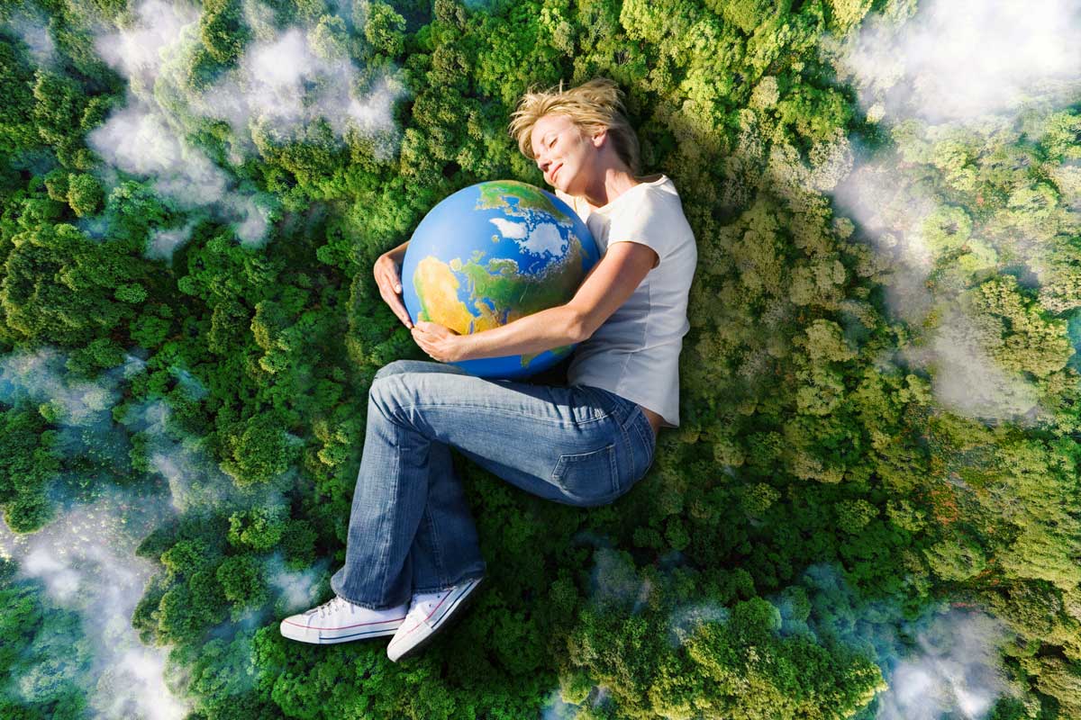 Mujer abrazando una pelota con el planeta tierra