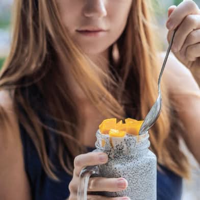 Mujer joven comiendo chia pudding